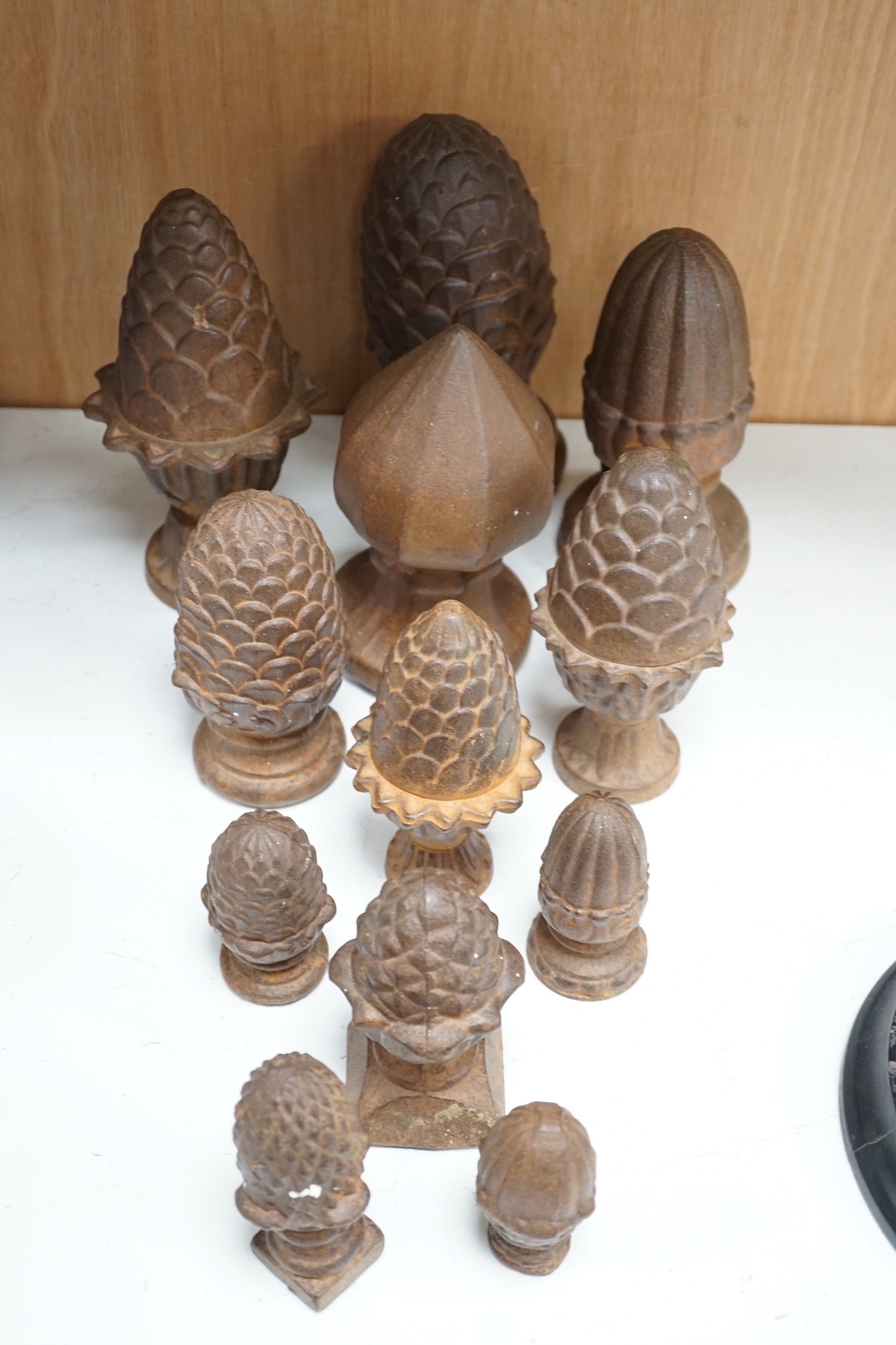 A group of cast iron finials, some with pine-cone decoration, tallest 21cm